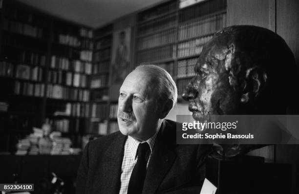 French novelist Jean Dutourd sits near a bust of himself. Dutourd, a member of the Academie Francaise since 1978, has just published the novel Le...