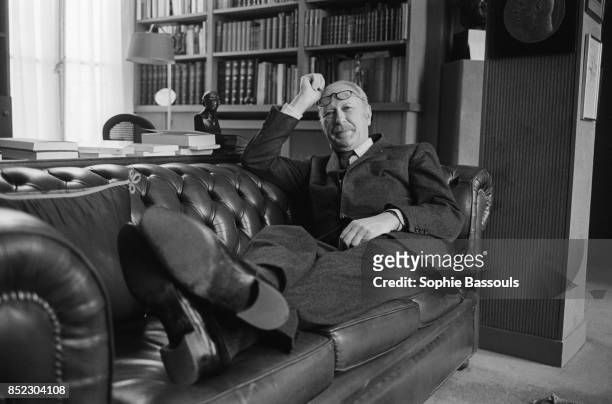 French novelist Jean Dutourd relaxes on a sofa. Dutourd, a member of the Academie Francaise since 1978, has just published the novel Le Seminaire de...