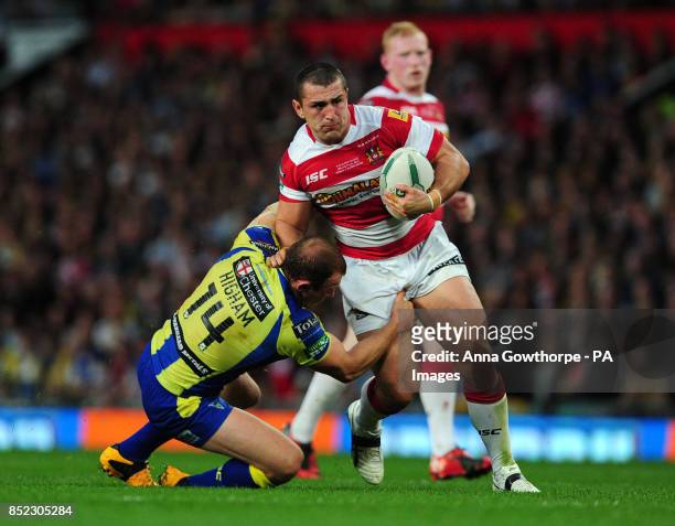 Wigan Warriors' Ben Flower is tackled by Warrington Wolves' Micky Higham during the Super League Grand Final at Old Trafford, Manchester.