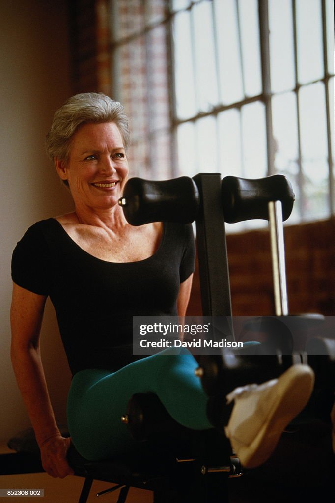 Mature woman doing weight training in gym