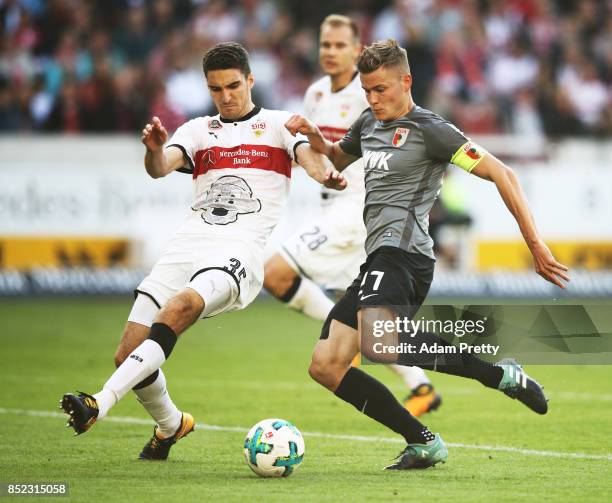 Alfred Finnbogason of Augsburg is challenged by Marcin Kaminski of VfB Stuttgart during the Bundesliga match between VfB Stuttgart and FC Augsburg at...