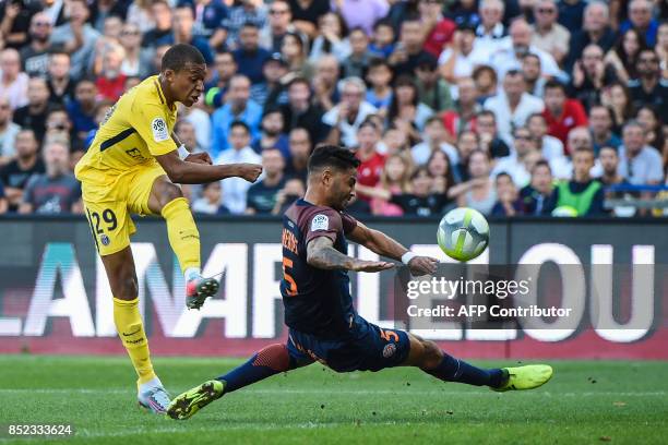 Paris Saint-Germain's French forward Kylian Mbappe shoots on goal despite Montpellier's Portuguese defender Pedro Mendes during the French Ligue 1...