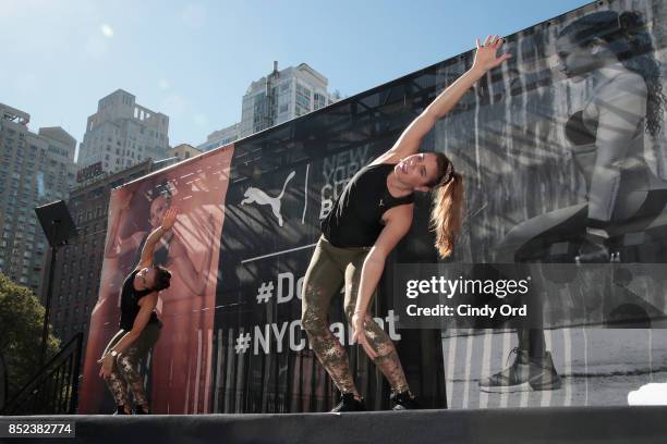 Trainers leading a workout on stage at the first ever workout session in Lincoln Center hosted by PUMA & New York City Ballet on September 23, 2017...