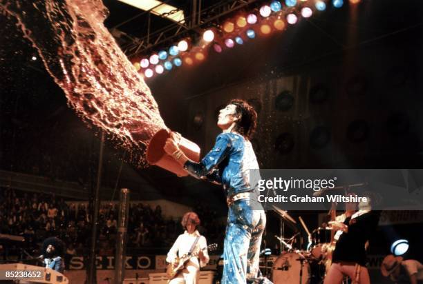 Photo of ROLLING STONES; Mick Jagger throwing bucket of water at crowd, performing live onstage on 1973 European tour