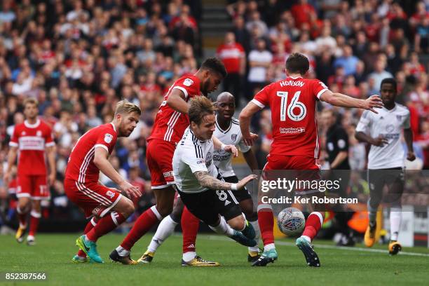 Stefan Johansen of Fulham holds off the challenge of Cyrus Christie and Jonny Howson of Middlesbrough during the Sky Bet Championship match between...