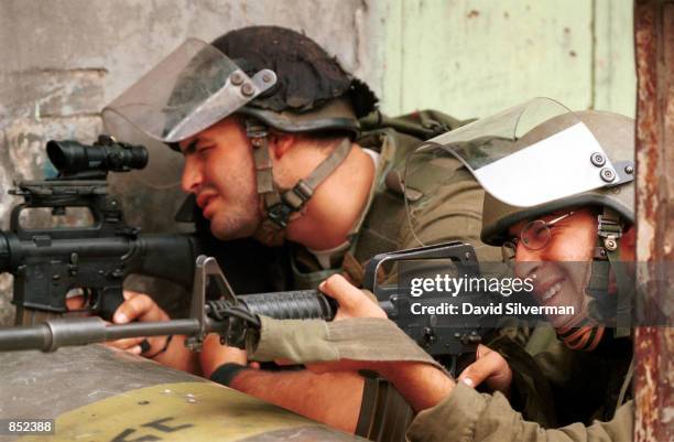 Israeli soldiers aim at stone-throwing Palestinians during rioting October 3, 2000 in the West Bank city of Hebron, Jerusalem. Clashes between...