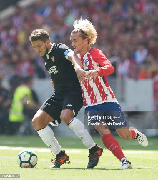 Daniel Carrico of Sevilla FC fends off Antoine Greizmann of Club Atletico de Madrid during the La Liga match between Atletico Madrid and Sevilla at...