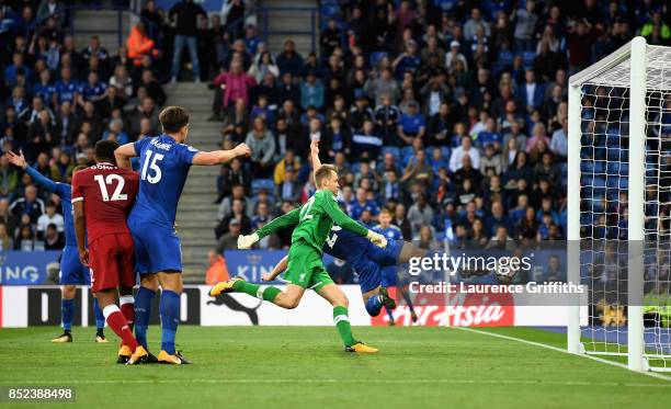 Simon Mignolet of Liverpool attempts to save as Shinji Okazaki of Leicester City scores his sides first goal during the Premier League match between...