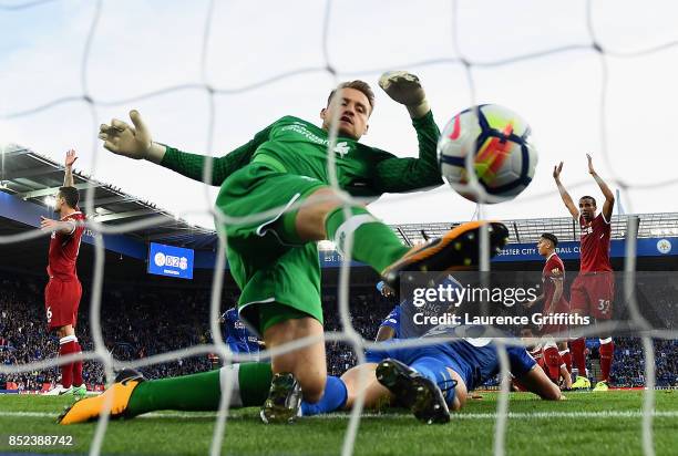 Simon Mignolet of Liverpool attempts to save as Shinji Okazaki of Leicester City scores his sides first goal during the Premier League match between...