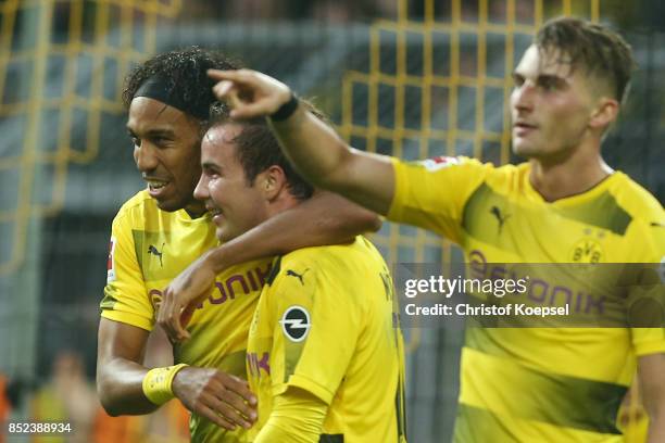 Pierre-Emerick Aubameyang of Dortmund celebrates with Mario Goetze of Dortmund and Maximilian Philipp of Dortmund after he scored his teams third...