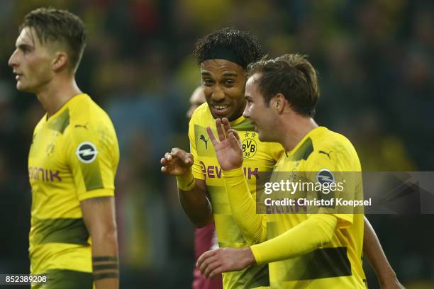 Pierre-Emerick Aubameyang of Dortmund celebrates with Mario Goetze of Dortmund and Maximilian Philipp of Dortmund after he scored his teams third...