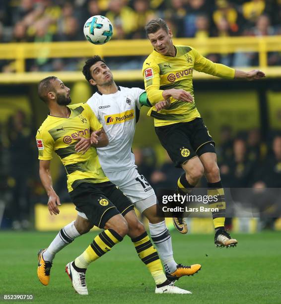 Oemer Toprak of Dortmund , Lars Stindl of Moenchengladbach and Lukasz Piszczek of Dortmund fight for the ball during the Bundesliga match between...