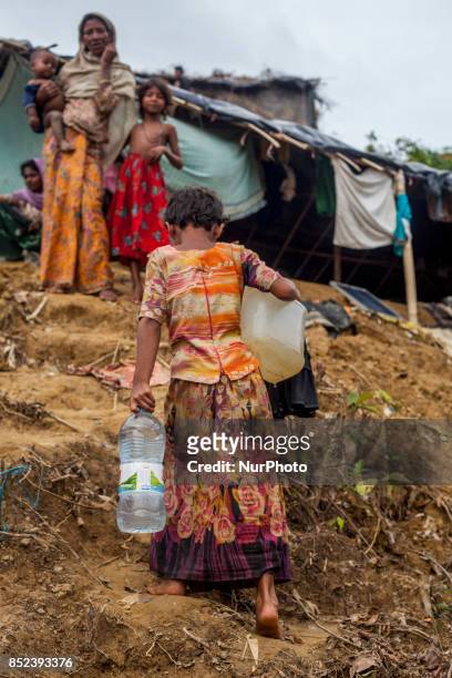 Balukhali camp resident collects drinking water from mud and clay as the supply of drinking water is inadequate. They dug a 3 to 4 feet circular or...