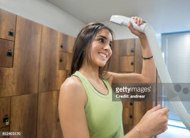woman getting ready in the lockers room at the gym - bathroom exercise stock pictures, royalty-free photos & images