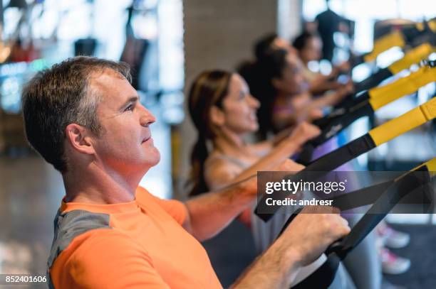 group of people sspension training at the gym - suspension training stock pictures, royalty-free photos & images