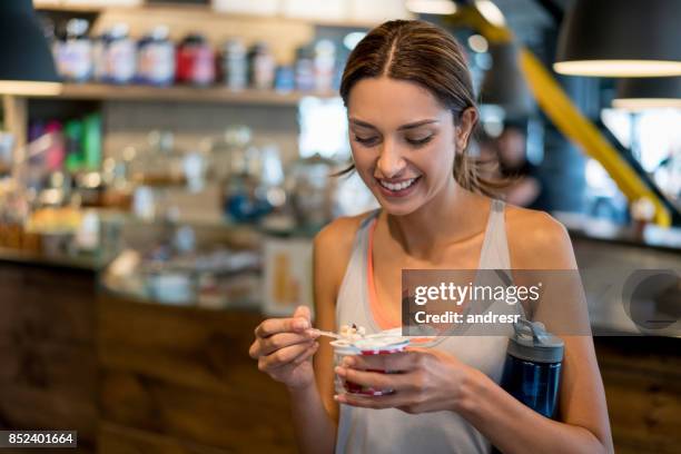 woman eating a healthy snack at the gym - healthy snacks stock pictures, royalty-free photos & images