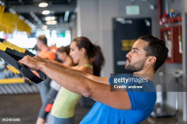 man at the gym trying a suspension training class - suspension training stock pictures, royalty-free photos & images