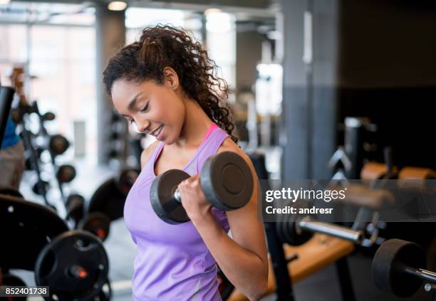 athletic woman exercising at the gym lifting weights - weightlifting stock pictures, royalty-free photos & images