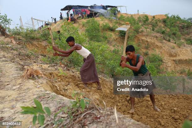 Rohingya Muslims work on a field with mattocks at a makeshift camp in Teknaff, Bangladesh on September 23, 2017. Violence erupted in Myanmars Rakhine...