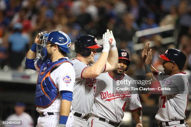 Adam Lind of the Washington Nationals is congratulated by team mates at the plate after hitting a three run home run in the third inning driving in...