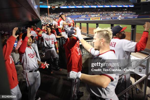 Adam Lind of the Washington Nationals is congratulated by team mates as he returns to the dugout after hitting a three run home run in the third...