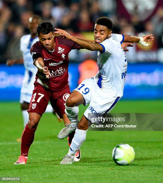 Metz' French-Togolese forward Mathieu Dossevi vies for the ball with Troyes' French midfielder Tristan Dingome during the French L1 football match...