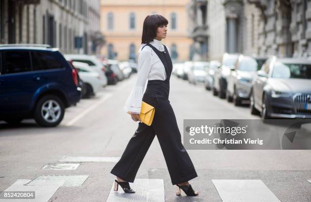 Kat Graham wearing black Philosophy jumpsuit, white Fendi blouse , yellow Valextra clutch , heeled shoes Topshop is seen during Milan Fashion Week...