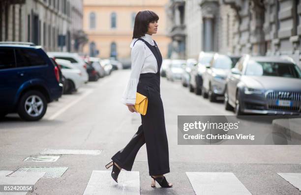 Kat Graham wearing black Philosophy jumpsuit, white Fendi blouse , yellow Valextra clutch , heeled shoes Topshop is seen during Milan Fashion Week...