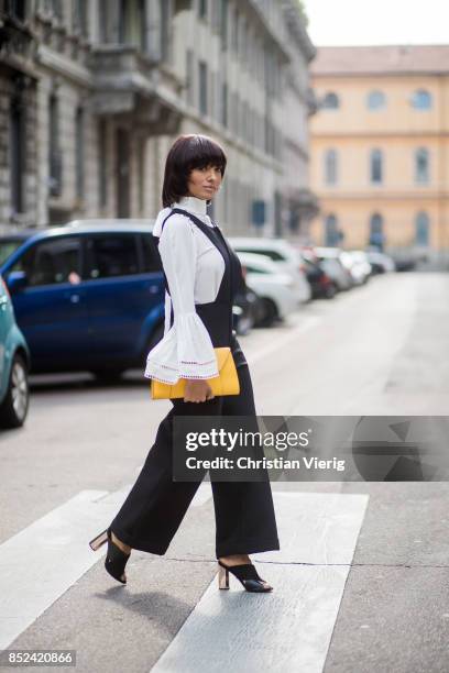 Kat Graham wearing black Philosophy jumpsuit, white Fendi blouse , yellow Valextra clutch , heeled shoes Topshop is seen during Milan Fashion Week...