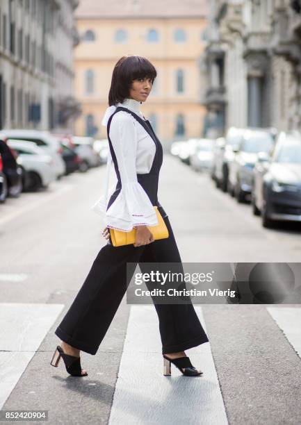 Kat Graham wearing black Philosophy jumpsuit, white Fendi blouse , yellow Valextra clutch , heeled shoes Topshop is seen during Milan Fashion Week...
