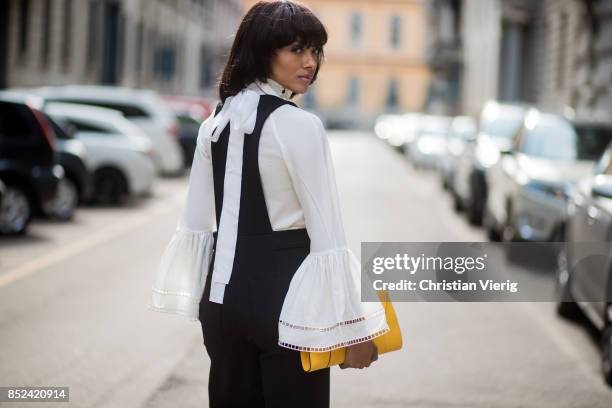 Kat Graham wearing black Philosophy jumpsuit, white Fendi blouse , yellow Valextra clutch , heeled shoes Topshop is seen during Milan Fashion Week...