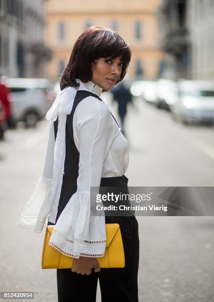Kat Graham wearing black Philosophy jumpsuit, white Fendi blouse , yellow Valextra clutch , heeled shoes Topshop is seen during Milan Fashion Week...