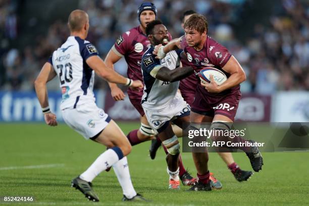 Union Bordeaux Begles' South African lock Jandre Marais is tackled by Montpellier's French number 8 Fulgence Ouedraogo during the French Top 14 rugby...