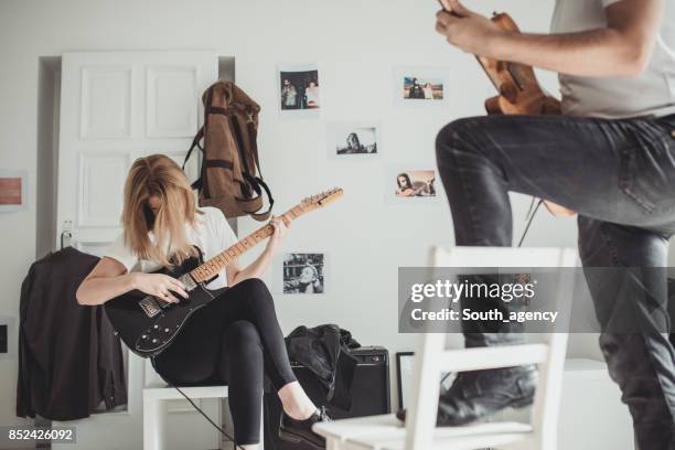 young couple playing guitar together - head banging stock pictures, royalty-free photos & images
