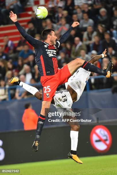Caen's French midfielder Julien Feret and Amiens' Congolese midfielder Gael Kakuta go for a header during the French L1 football match between Caen...