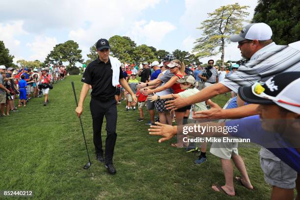 Jordan Spieth of the United States greets fans as he walks to the sixth hole during the third round of the TOUR Championship at East Lake Golf Club...