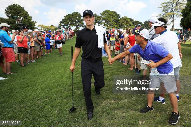Jordan Spieth of the United States greets fans as he walks to the sixth hole during the third round of the TOUR Championship at East Lake Golf Club...