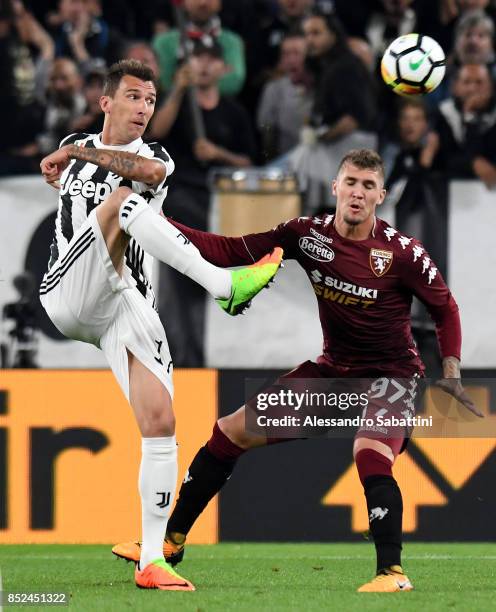 Mario Mandzukic of Juventus competes for the ball whit Evangelista Lyanco of Torino FC during the Serie A match between Juventus and Torino FC on...