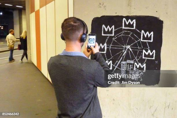 Passers by stop to take photos of a new artwork by street artist Banksy at the Barbican Centre on September 19, 2017 in London, England. The two new...