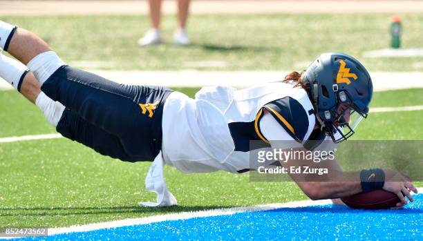 Quarterback Will Grier of the West Virginia Mountaineers dives into the end zone for a touchdown against the Kansas Jayhawks in the fourth quarter at...