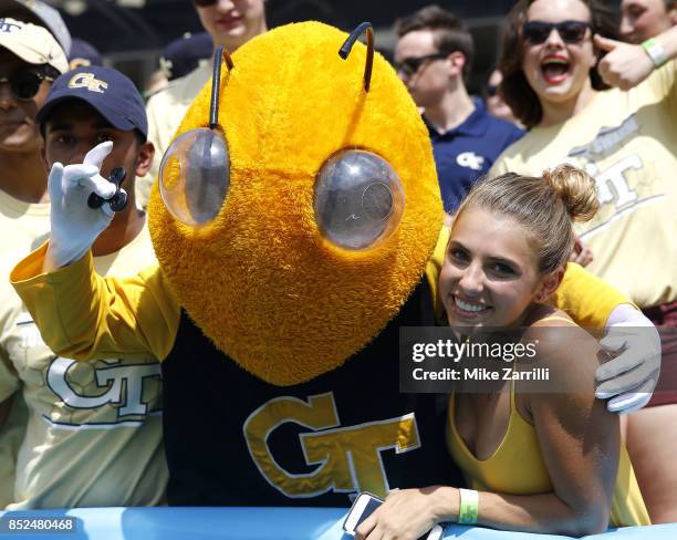 Georgia Tech Yellow Jackets mascot Buzz poses with a fan holding a fidget spinner during the game against the Pittsburgh Panthers at Bobby Dodd...