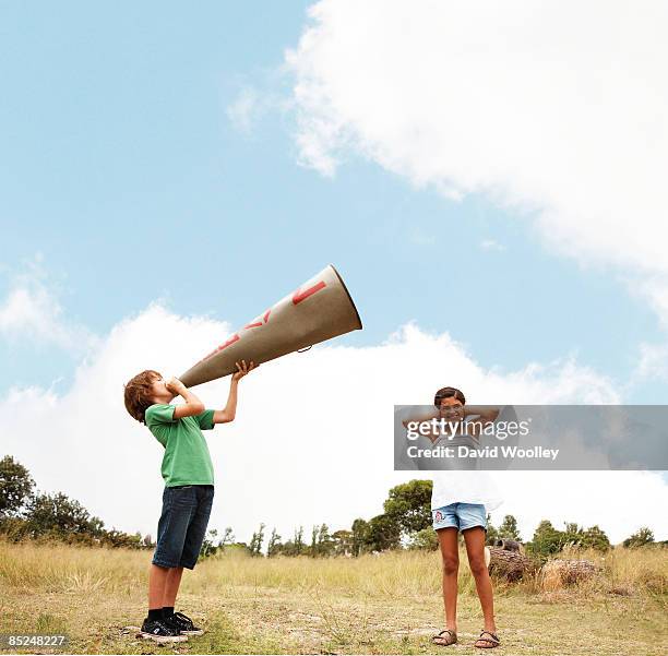 boy holding megaphone, girl blocking her ears - problemi di comunicazione foto e immagini stock