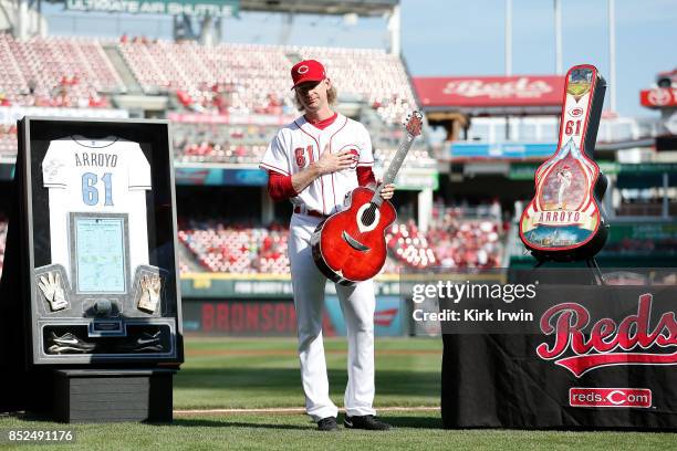 Bronson Arroyo of the Cincinnati Reds shows his appreciation after being given a shadow box made with his jersey, batting gloves, cleats, ball and...