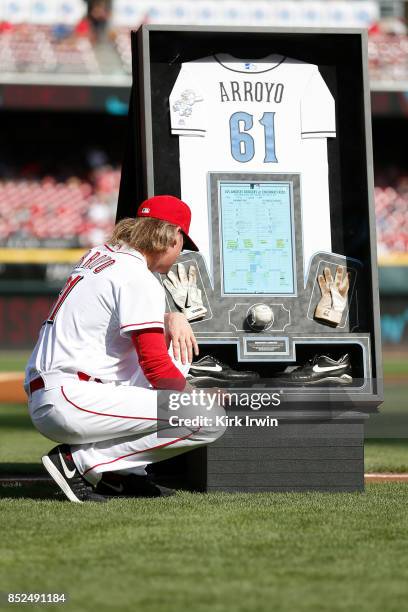 Bronson Arroyo of the Cincinnati Reds looks at shadow box made with his jersey, batting gloves, cleats, ball and score card from the last game that...