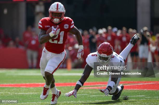 Running back Mikale Wilbon of the Nebraska Cornhuskers evades the tackle from linebacker Deonte Roberts of the Rutgers Scarlet Knights at Memorial...