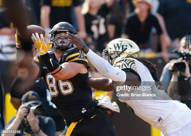 Tight end Levi Duffield of the Appalachian State Mountaineers hauls in a pass from quarterback Taylor Lamb in front of linebacker Jaboree Williams of...
