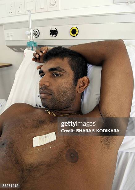 Sri Lankan cricketer Tharanga Paranavitana lies on his bed as he recuperates at a private hospital in Colombo on March 5, 2009. Two Sri Lankan...