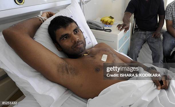 Sri Lankan cricketer Tharanga Paranavitana lies on his bed as he recuperates at a private hospital in Colombo on March 5, 2009. Two Sri Lankan...