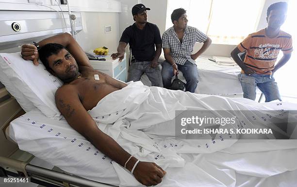 Sri Lankan cricketer Tharanga Paranavitana lies on his bed as he recuperates at a private hospital in Colombo on March 5, 2009. Two Sri Lankan...