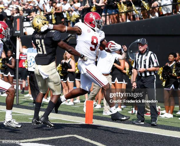Bo Scarbrough of the Alabama Crimson Tide pushes aside Tre Herndon of the Vanderbilt Commodores to score a touchdown against the Commodores during...